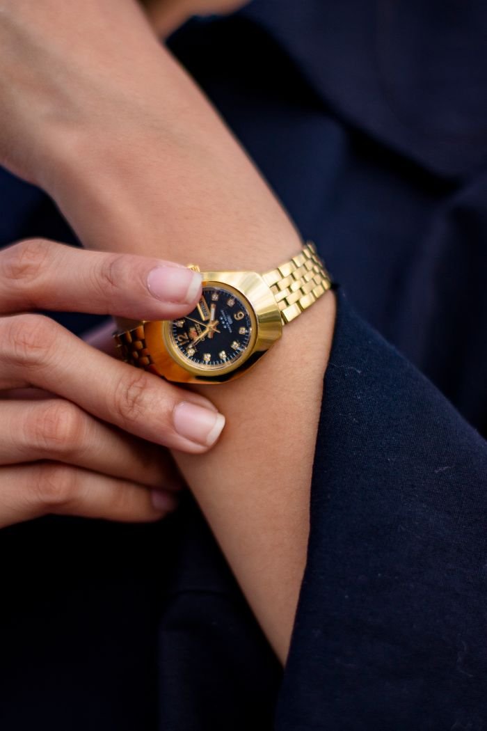 The Art of Drawing Readers In: Your attractive post title goes here Close-up of a stylish gold wristwatch being adjusted on a wrist, highlighting timekeeping elegance.
